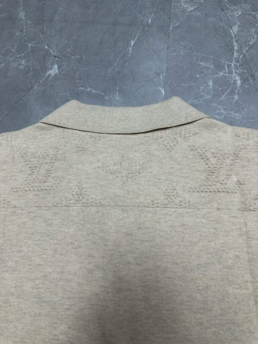 Light beige polo shirt back view, ribbed collar and smooth knit texture