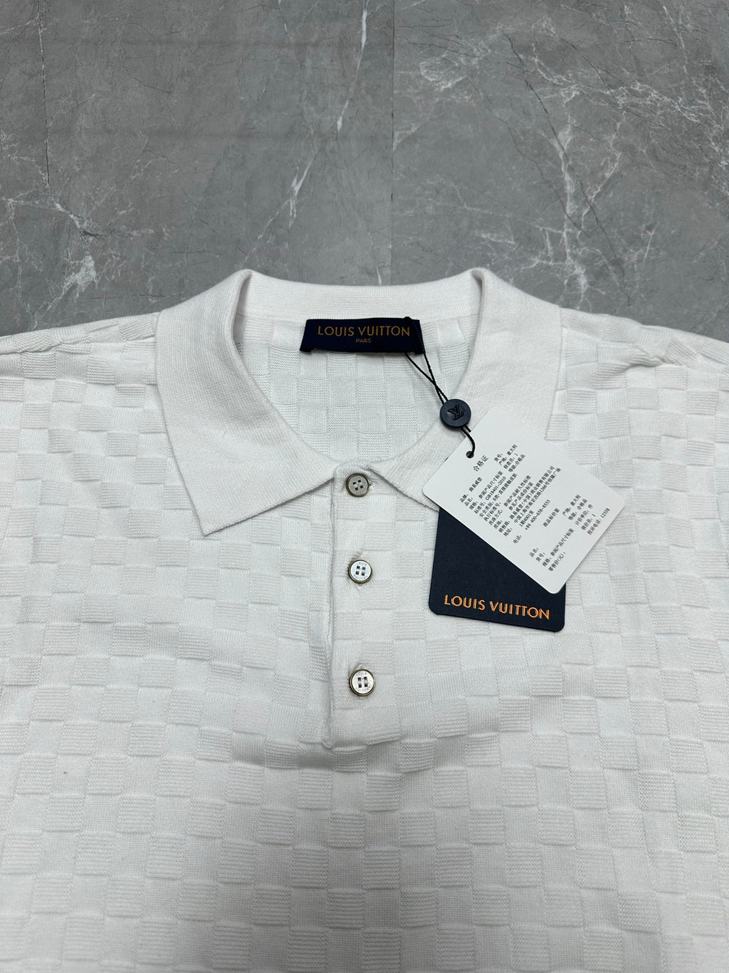 Louis Vuitton white polo shirt close-up: knit texture, three-button placket, round collar