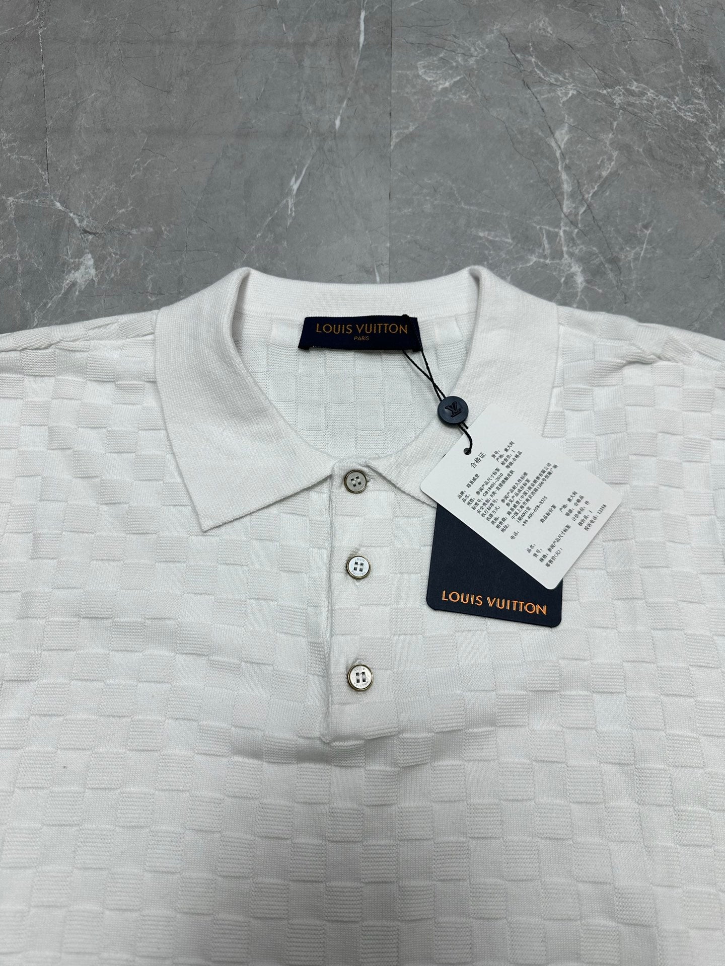 Louis Vuitton white polo shirt close-up: knit texture, three-button placket, round collar
