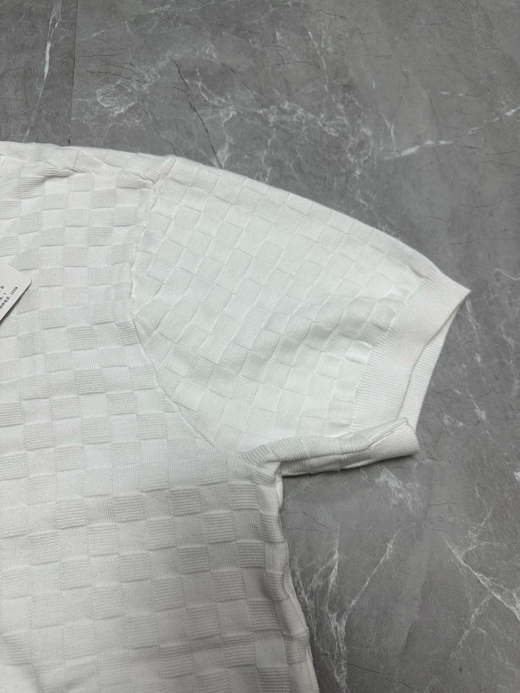 Louis Vuitton white polo shirt folded side profile with textured checker knit