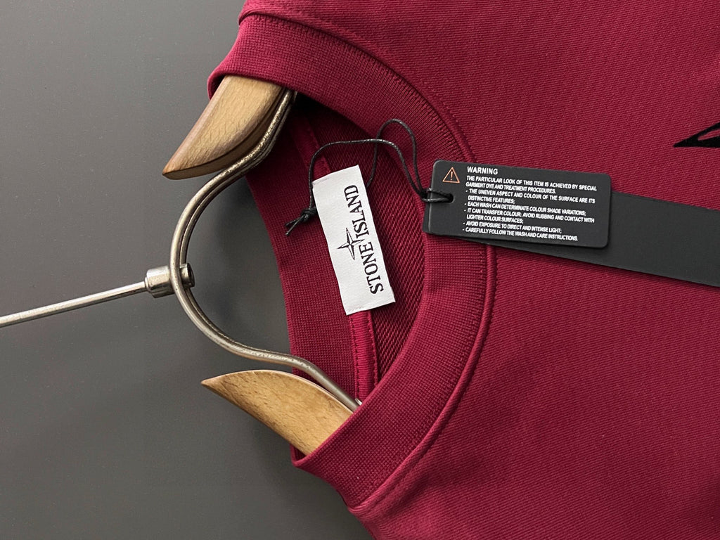 Stone Island polo-style sweatshirt collar with logo patch tag in maroon