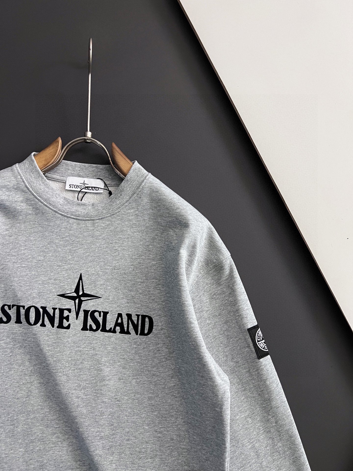 Grey crewneck sweatshirt with Stone Island chest logo and sleeve patch