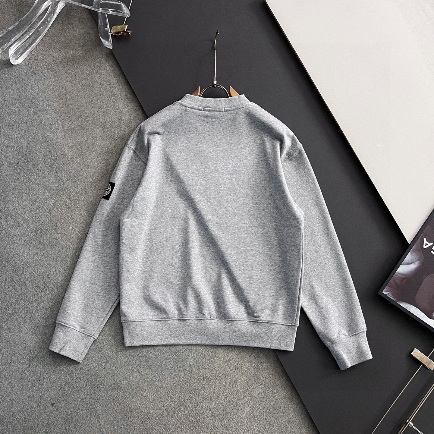 Grey sweatshirt back view with crew neckline and ribbed hem