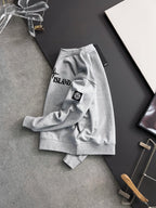 Grey sweatshirt laid flat with Stone Island chest logo and sleeve patch