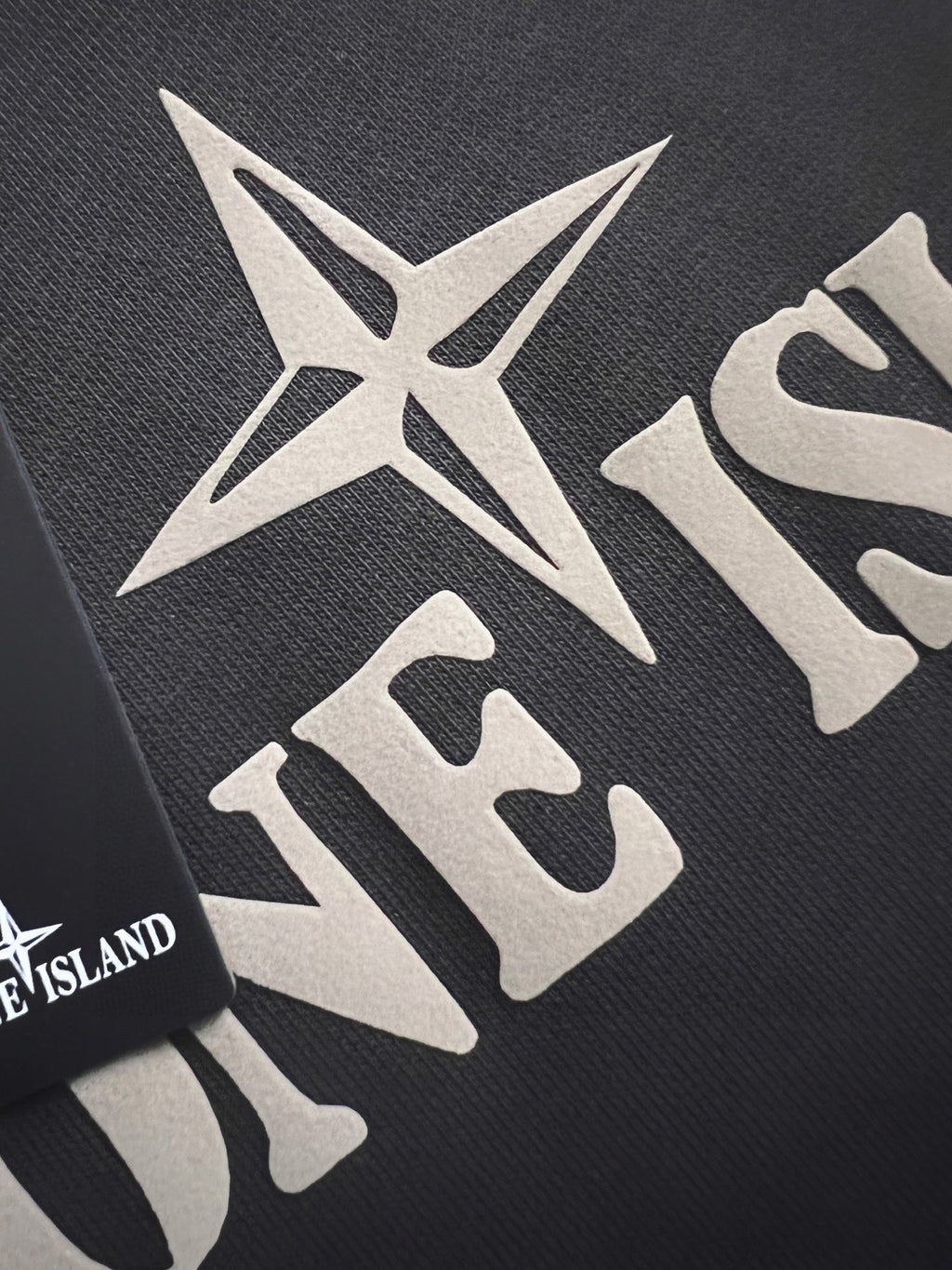 Stone Island sweatshirt fabric close-up with white star and text print