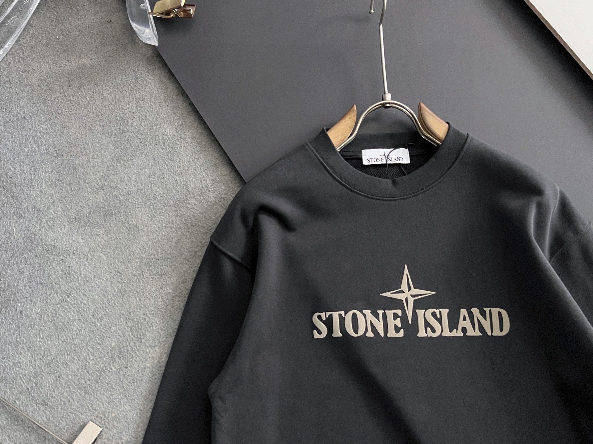 Stone Island sweatshirt close-up, black crewneck with large STONE ISLAND graphic