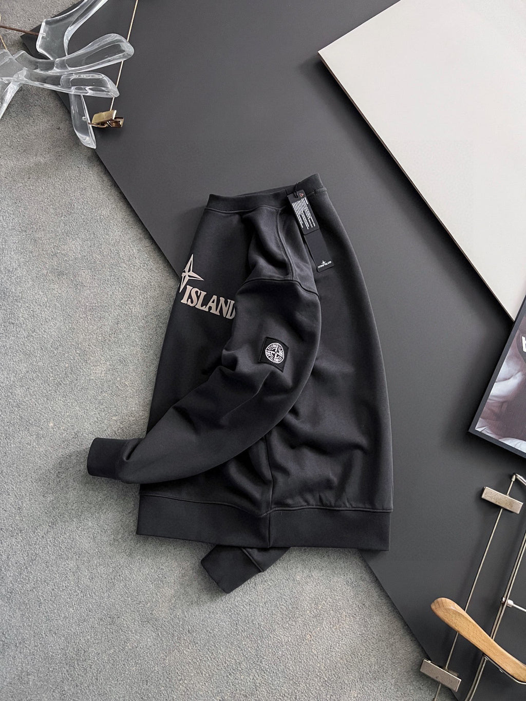 Stone Island sweatshirt side view, black with left sleeve crest patch