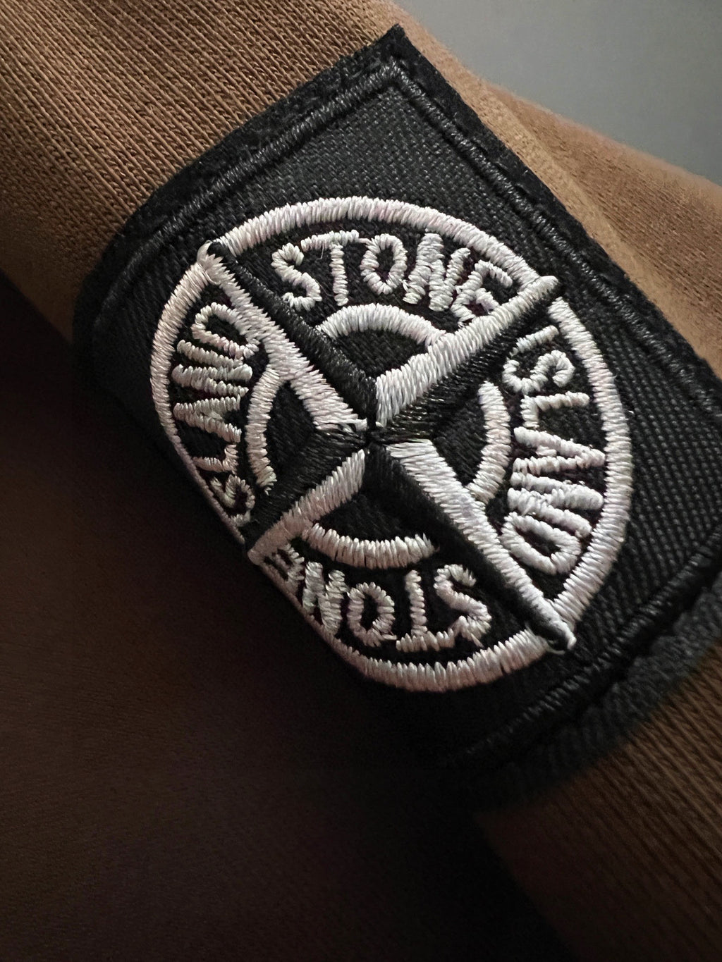 Embroidered Stone Island logo patch on dark sleeve cuff