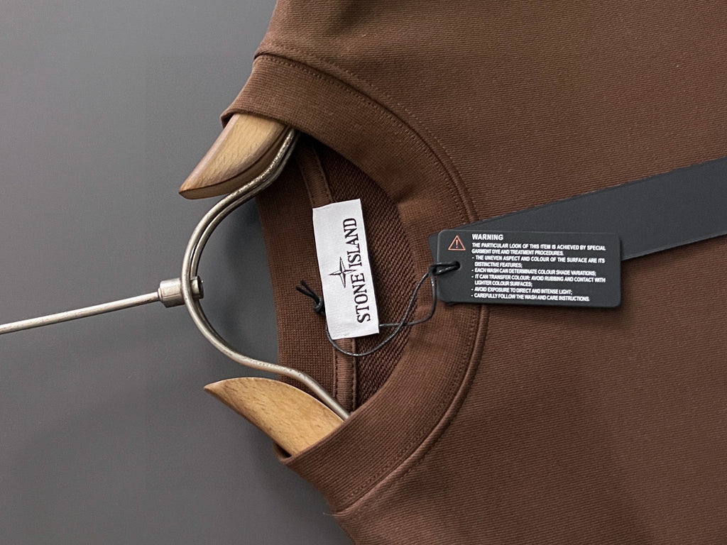 Brown crewneck sweatshirt collar with Stone Island label and neck tag