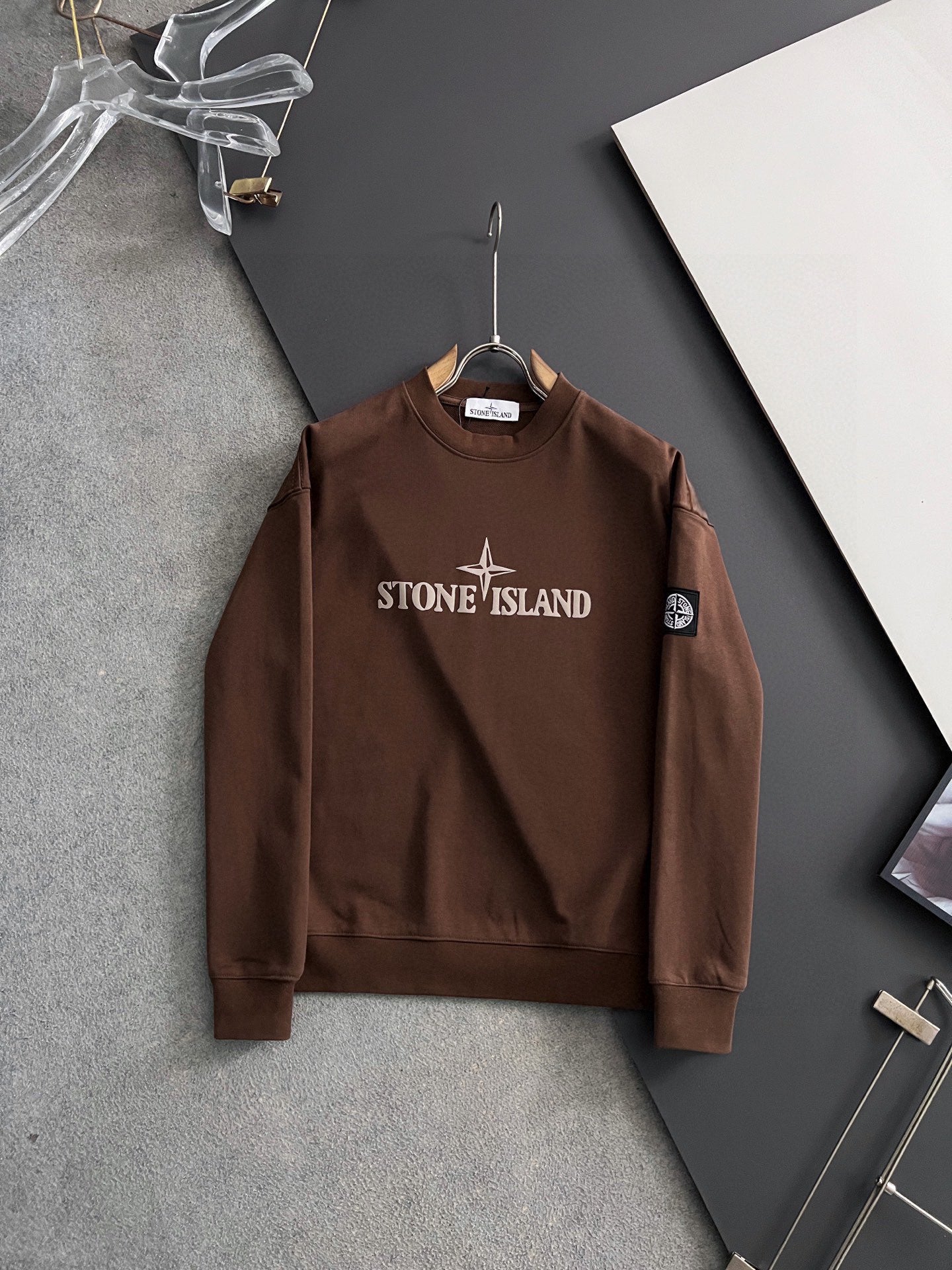 Brown crewneck sweatshirt with Stone Island chest logo and star badge on sleeve