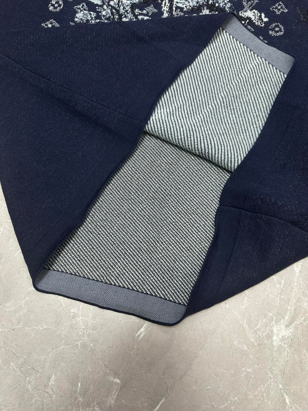 Louis Vuitton navy T-shirt folded close-up with black-and-white striped inner collar