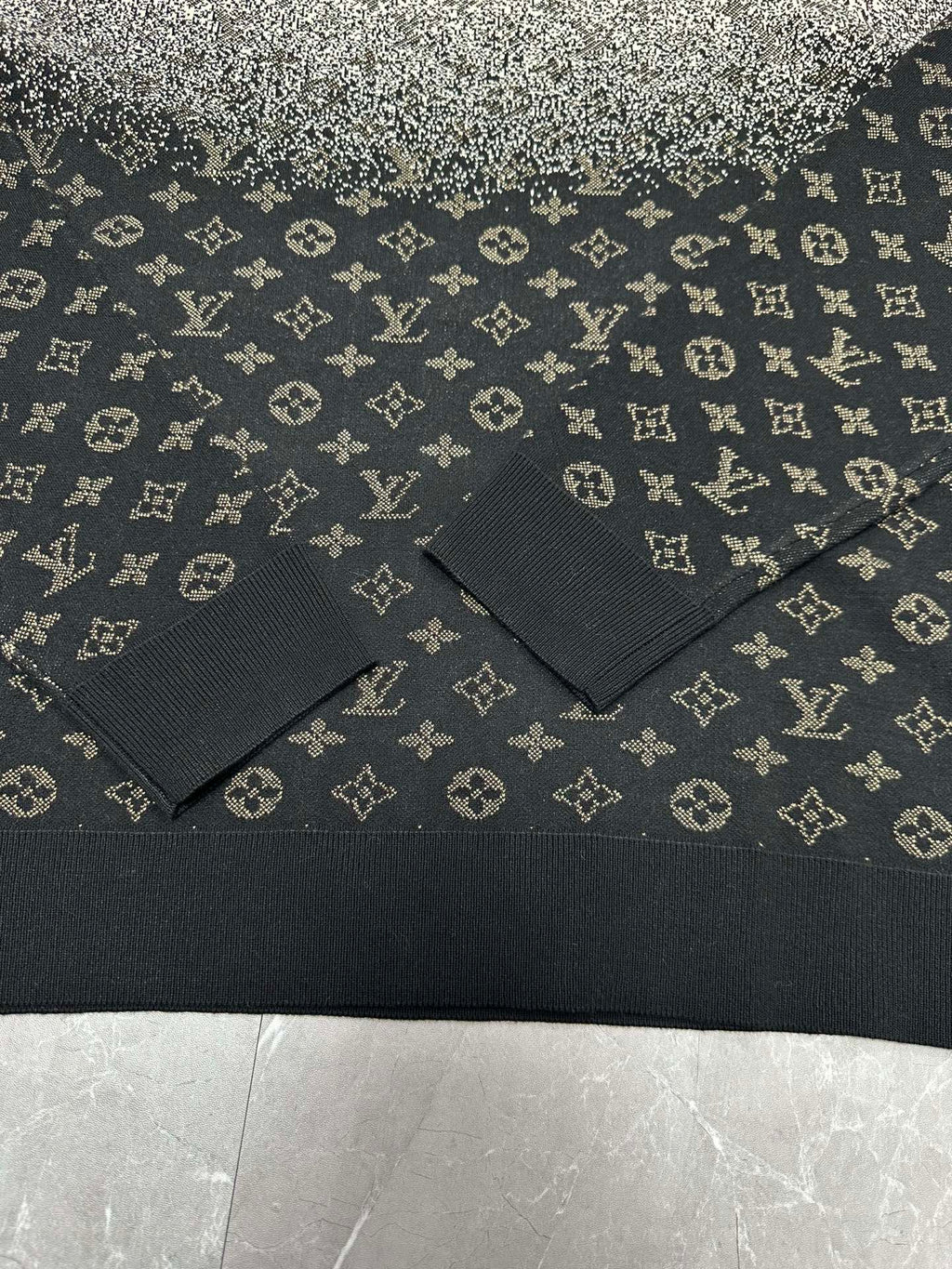 Ribbed hem and knit texture of monogram sweater in dark navy with light motifs