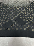 Ribbed hem and knit texture of monogram sweater in dark navy with light motifs