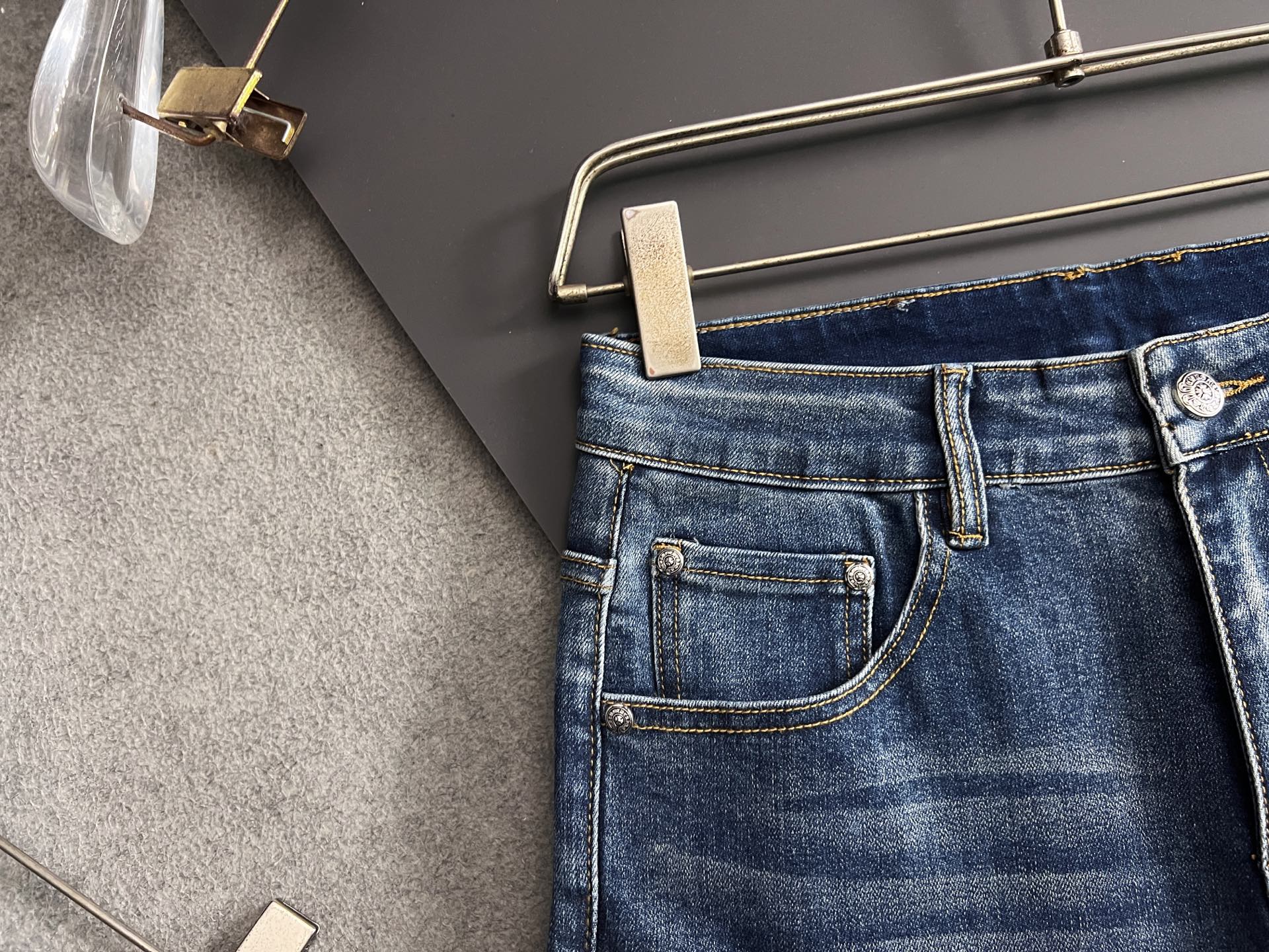 Blue denim pants with coin pocket, stitched waistband, and button fly