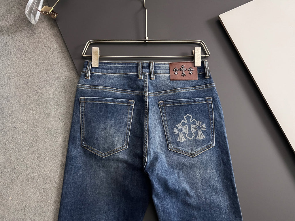 Blue denim pants with back pockets and embroidered cross-like emblem