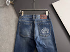 Blue denim pants with back pockets and embroidered cross-like emblem
