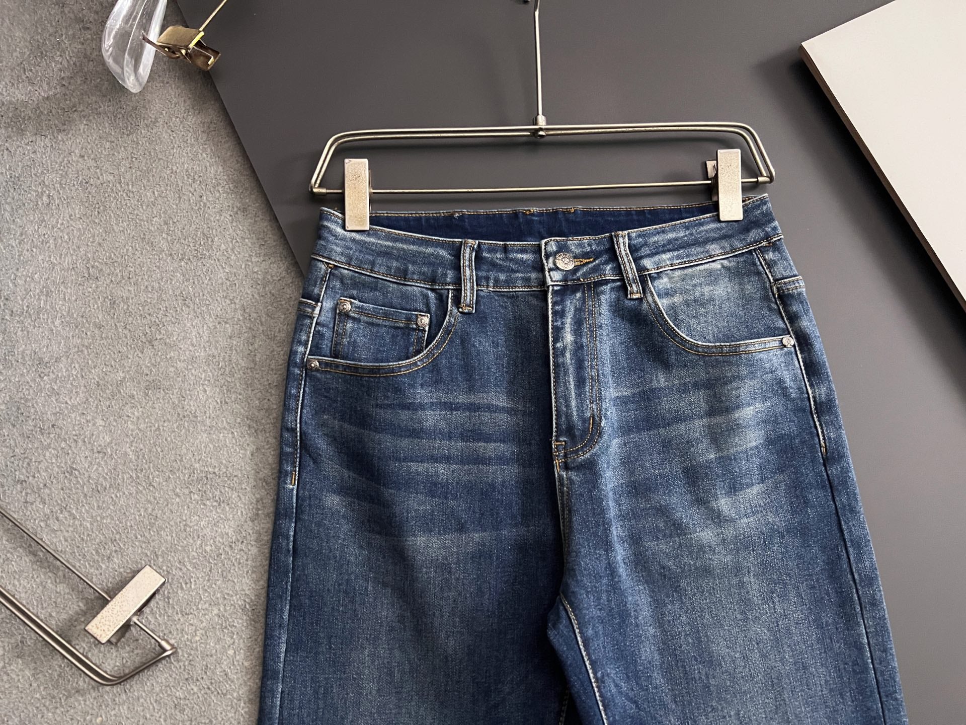 Blue denim pants with button fly and front pockets with contrast stitching
