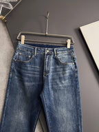 Blue denim pants with belt loops, button fly, and stitched waistband