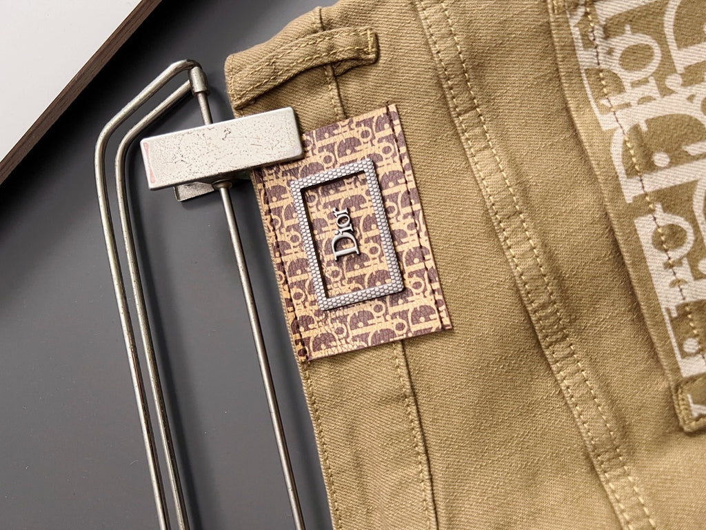 Olive Dior jeans close-up, waistband label and decorative logo patch