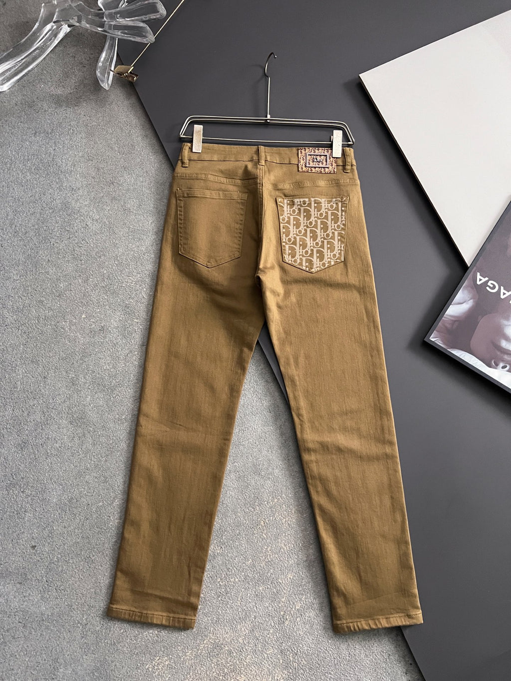 Olive Dior jeans on hanger, full length with logo back pocket patches