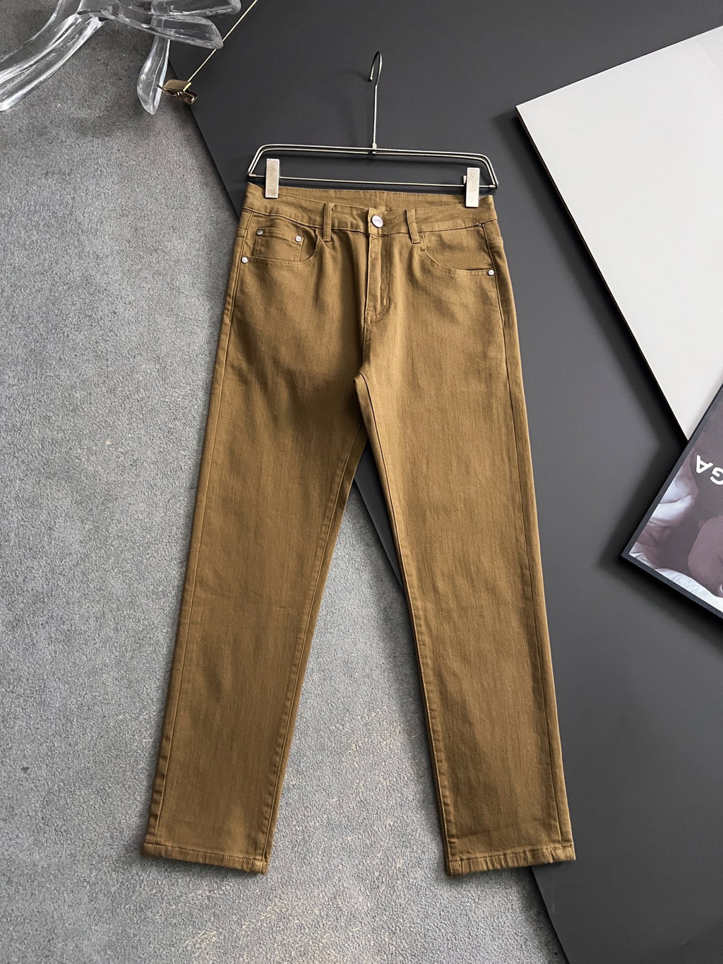 Olive Dior jeans on hanger, button fly and front pockets