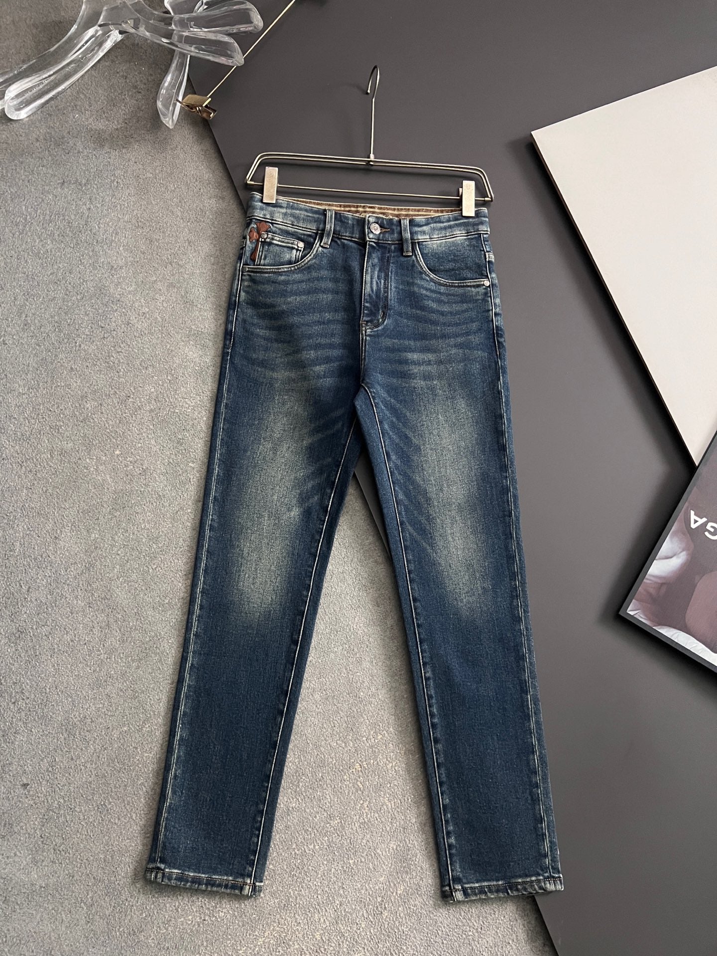 Blue denim jeans on hanger with straight leg and belt loops