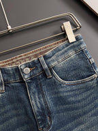 Blue denim jeans front pocket detail with metal button and stitching