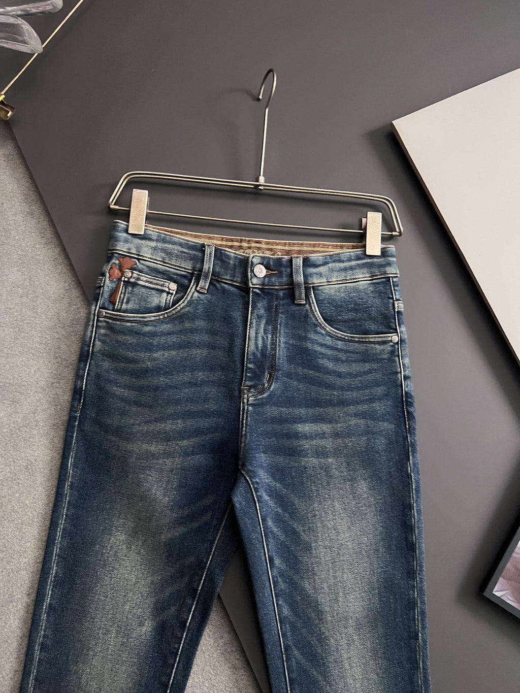 Blue denim jeans on hanger, back view with straight leg