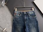 Blue denim jeans on hanger, front view with button and zip fly