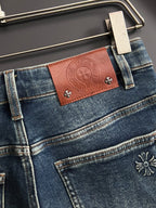 Blue denim jeans with brown leather-look waistband patch and small flower studs