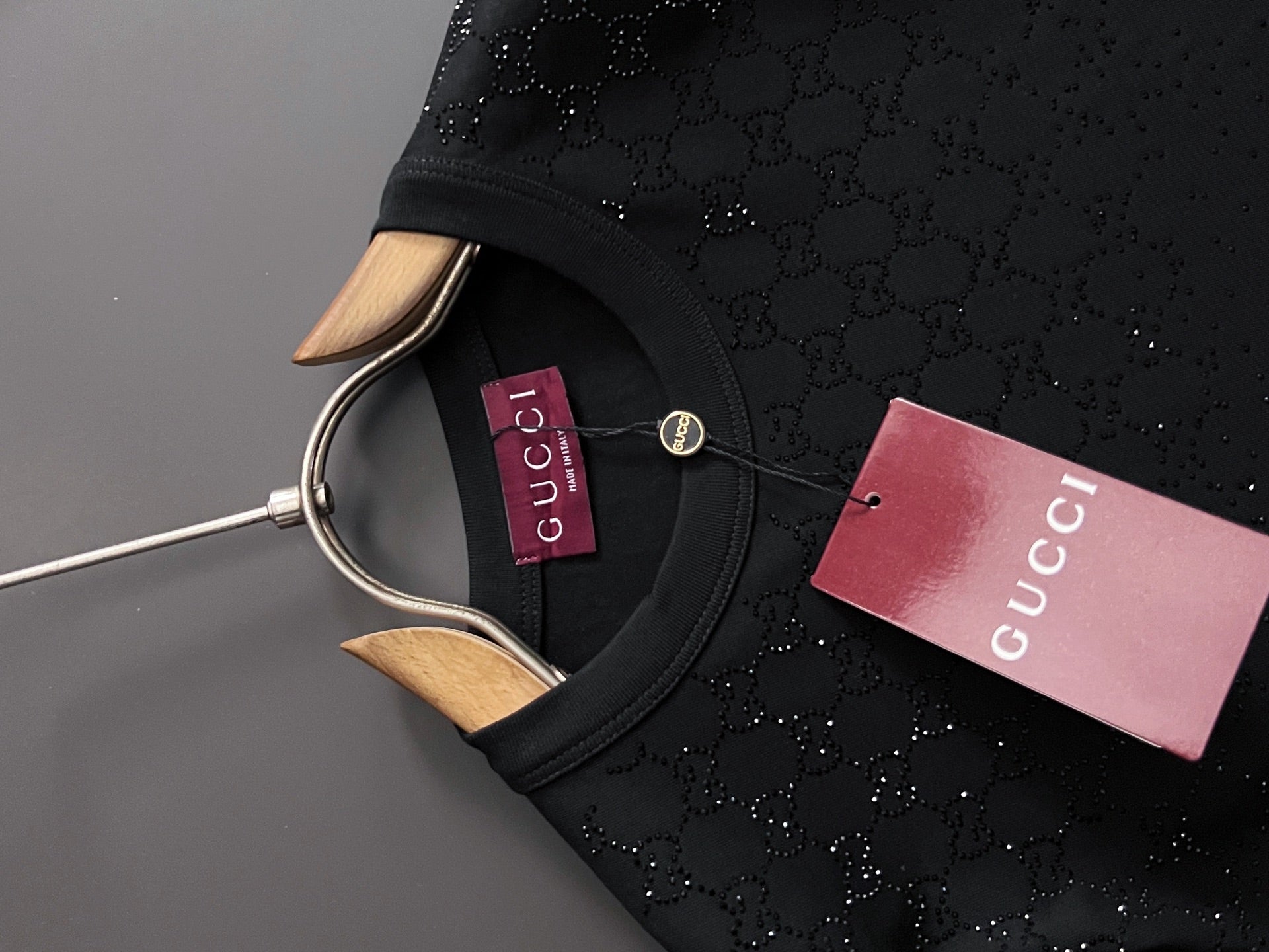 Black Gucci short-sleeve top close-up of crew neck with snap button detail