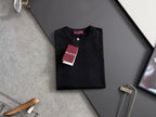 Black Gucci short-sleeve top with crew neck and dangling tag on hanger