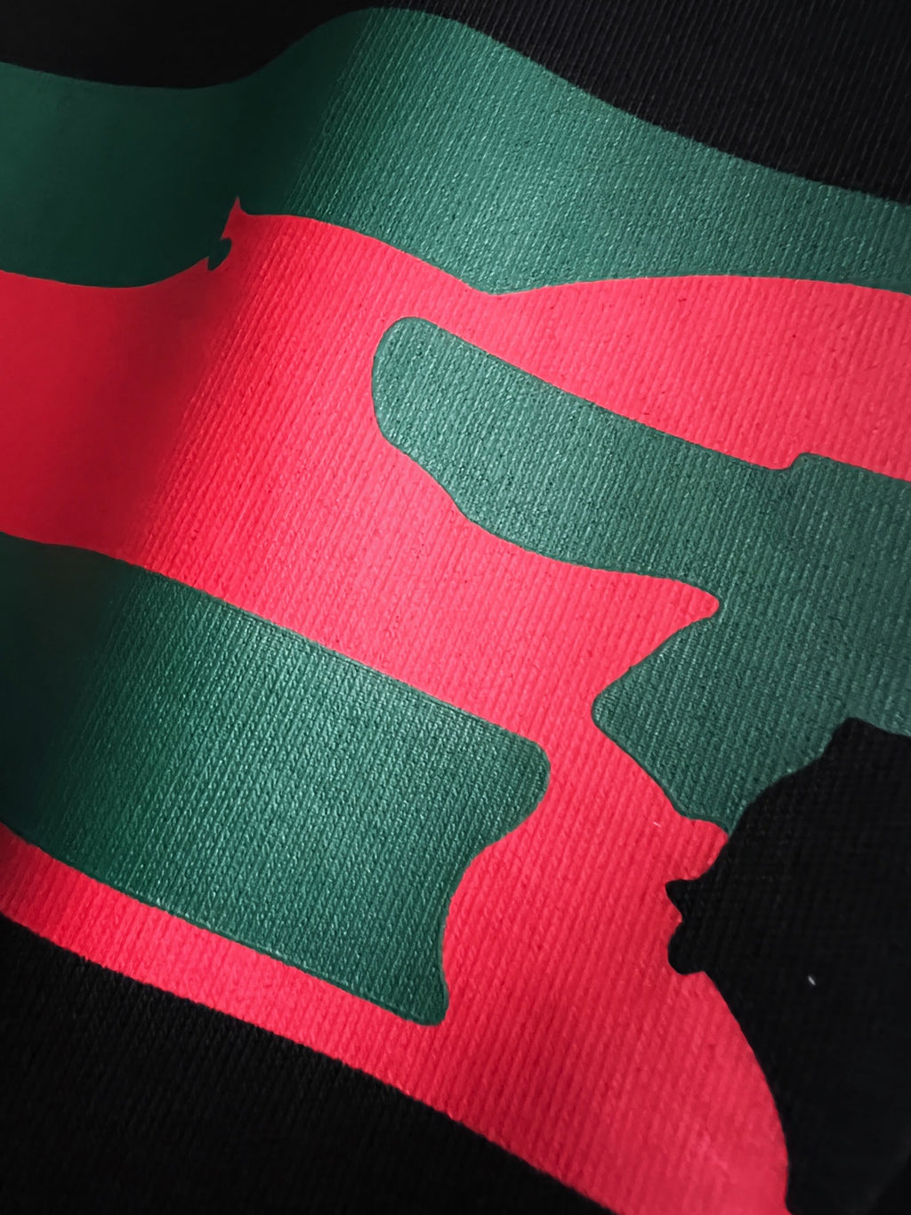 Close-up of green and red stripe graphic on black fabric
