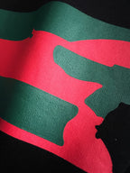 Close-up of green and red stripe graphic on black fabric
