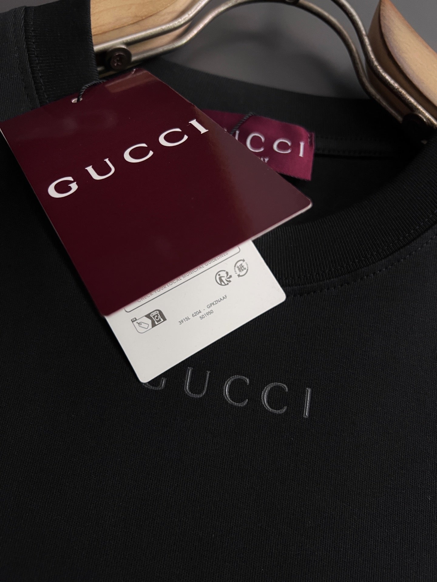 Black short-sleeve T-shirt close-up with Gucci label
