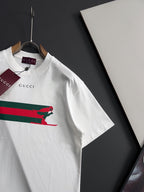 White short-sleeve T-shirt with multicolor stripe and green dog print, angled view