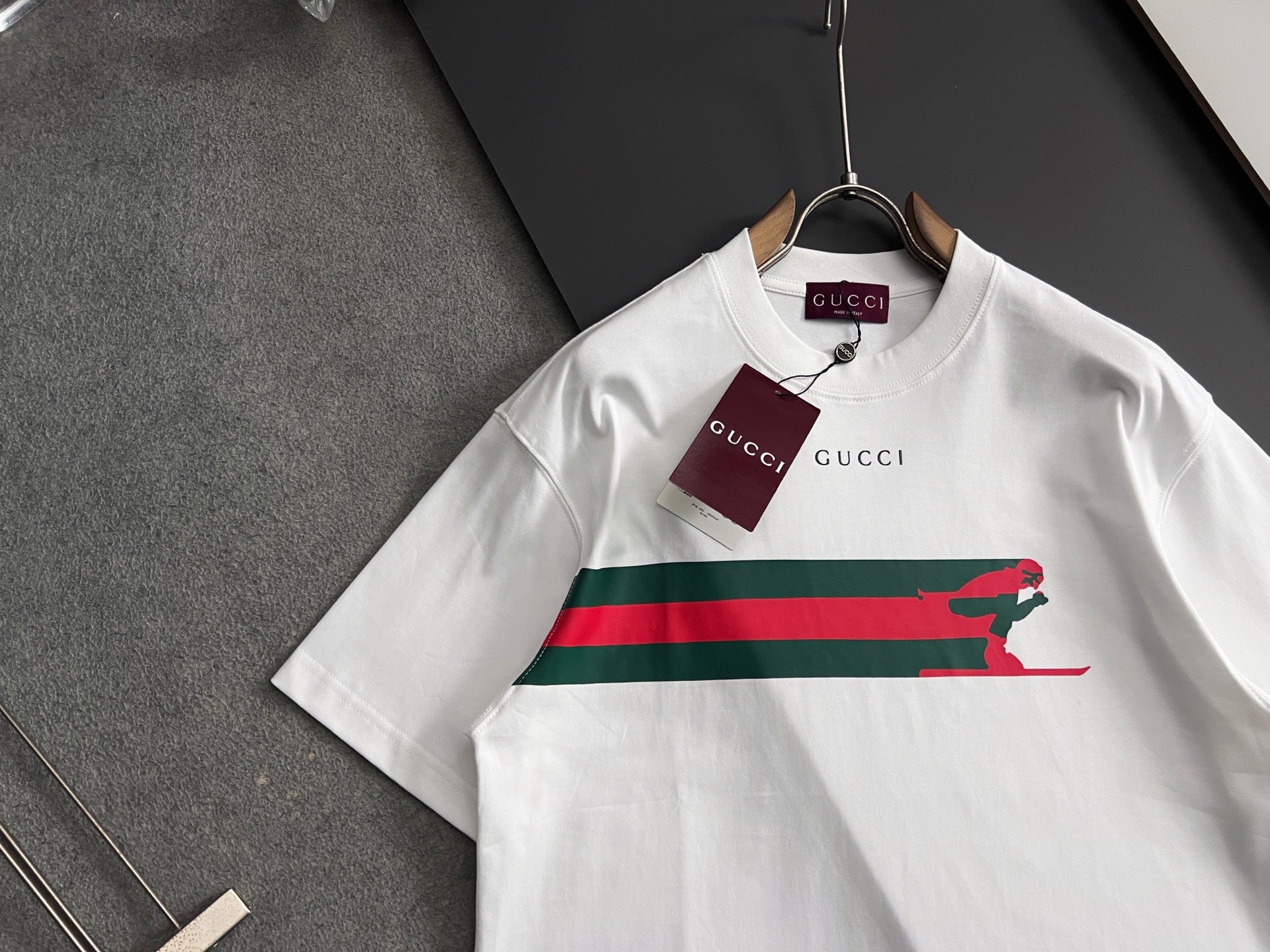 White short-sleeve T-shirt with green-red stripe and green dog graphic, Gucci logo