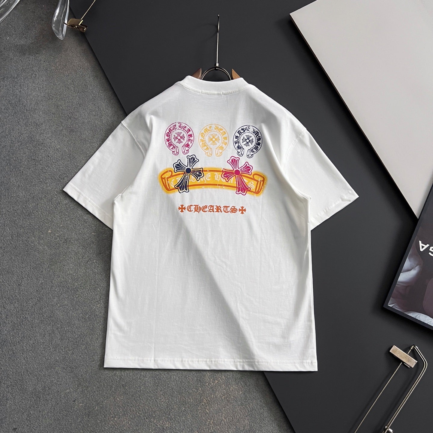 White short-sleeve T-shirt with multicolor crest and ribbon graphic