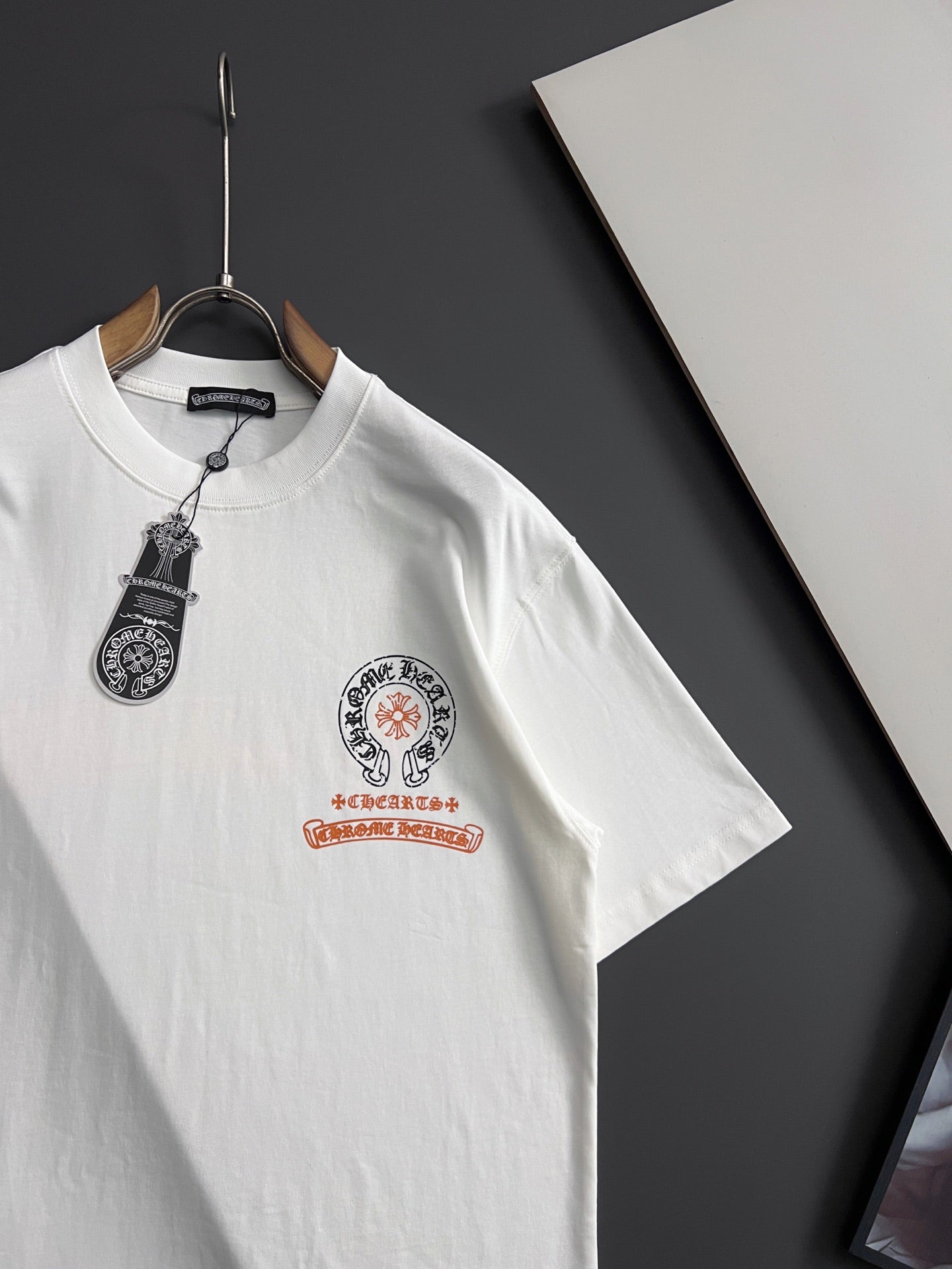 White short-sleeve T-shirt with front crest logo and hanging tag