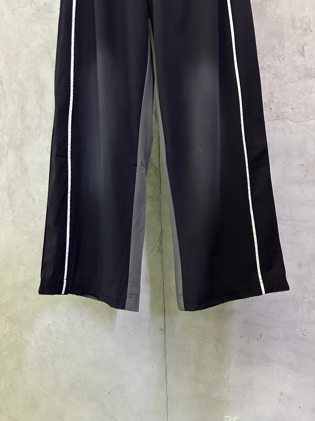 Dark navy wide-leg track pants with white side stripes and elastic waistband