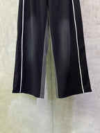 Dark navy wide-leg track pants with white side stripes and elastic waistband