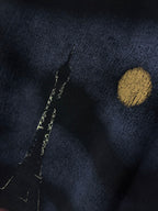 Graphic T-shirt close-up, dark navy fabric with gold dot and vertical marks