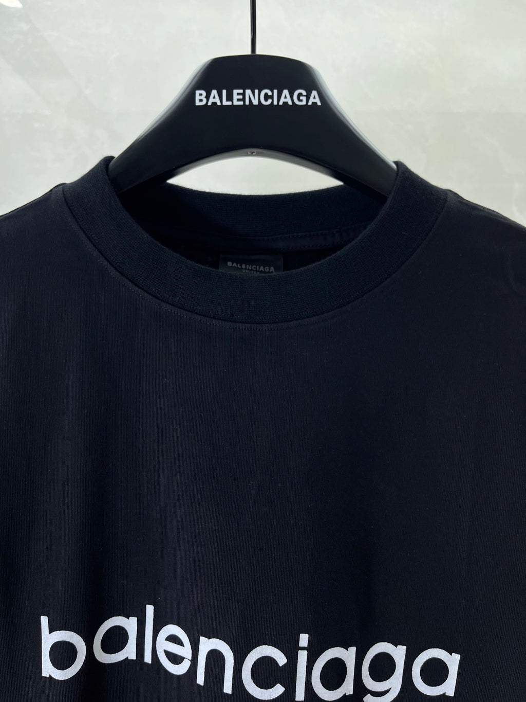 Dark navy T-shirt close-up of crew neck and 'BALENCIAGA' collar logo