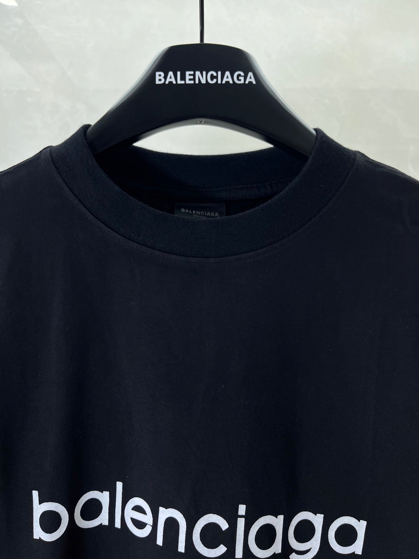 Dark navy T-shirt close-up of crew neck and 'BALENCIAGA' collar logo