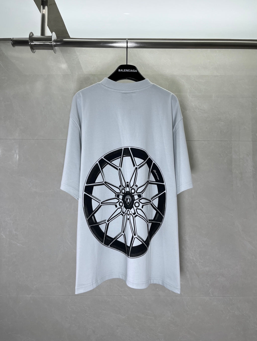Light blue short-sleeve T-shirt with large black wheel graphic print