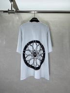 Light blue short-sleeve T-shirt with large black wheel graphic print