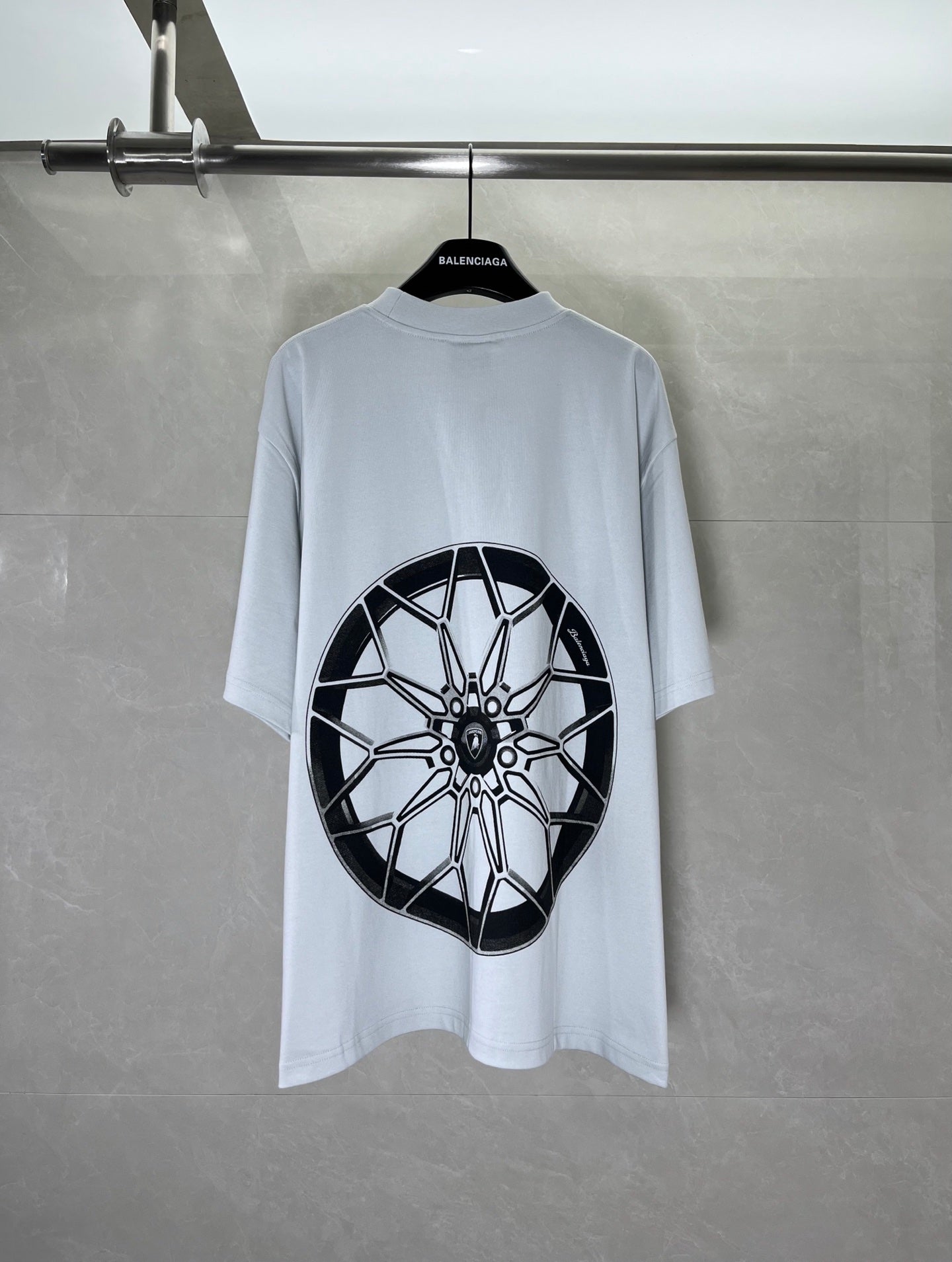 Light blue short-sleeve T-shirt with large black wheel graphic print