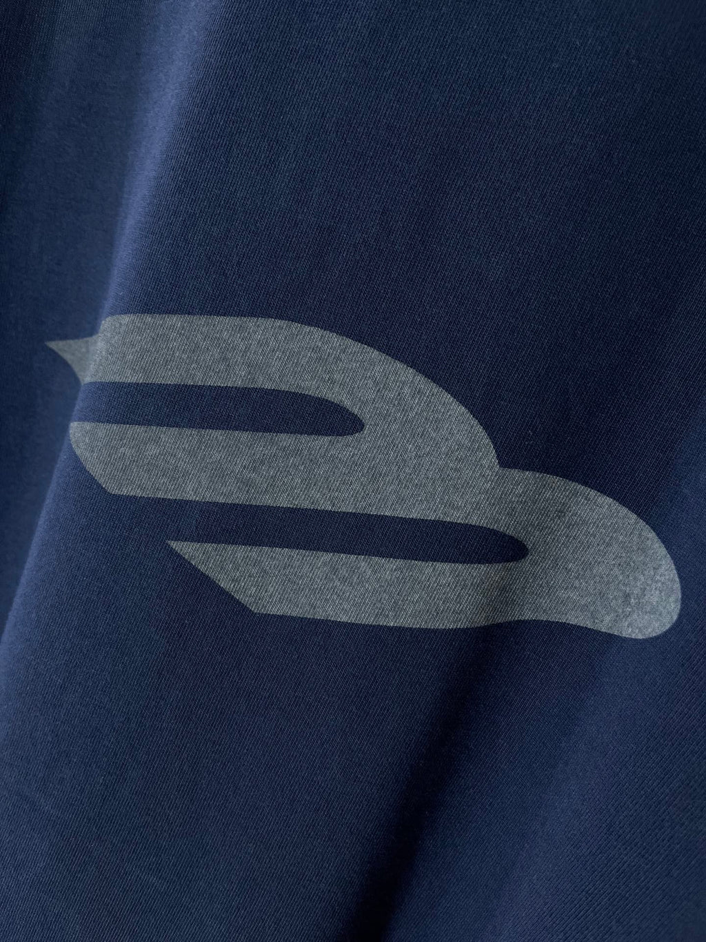 Navy T-shirt with large grey graphic detail on the chest
