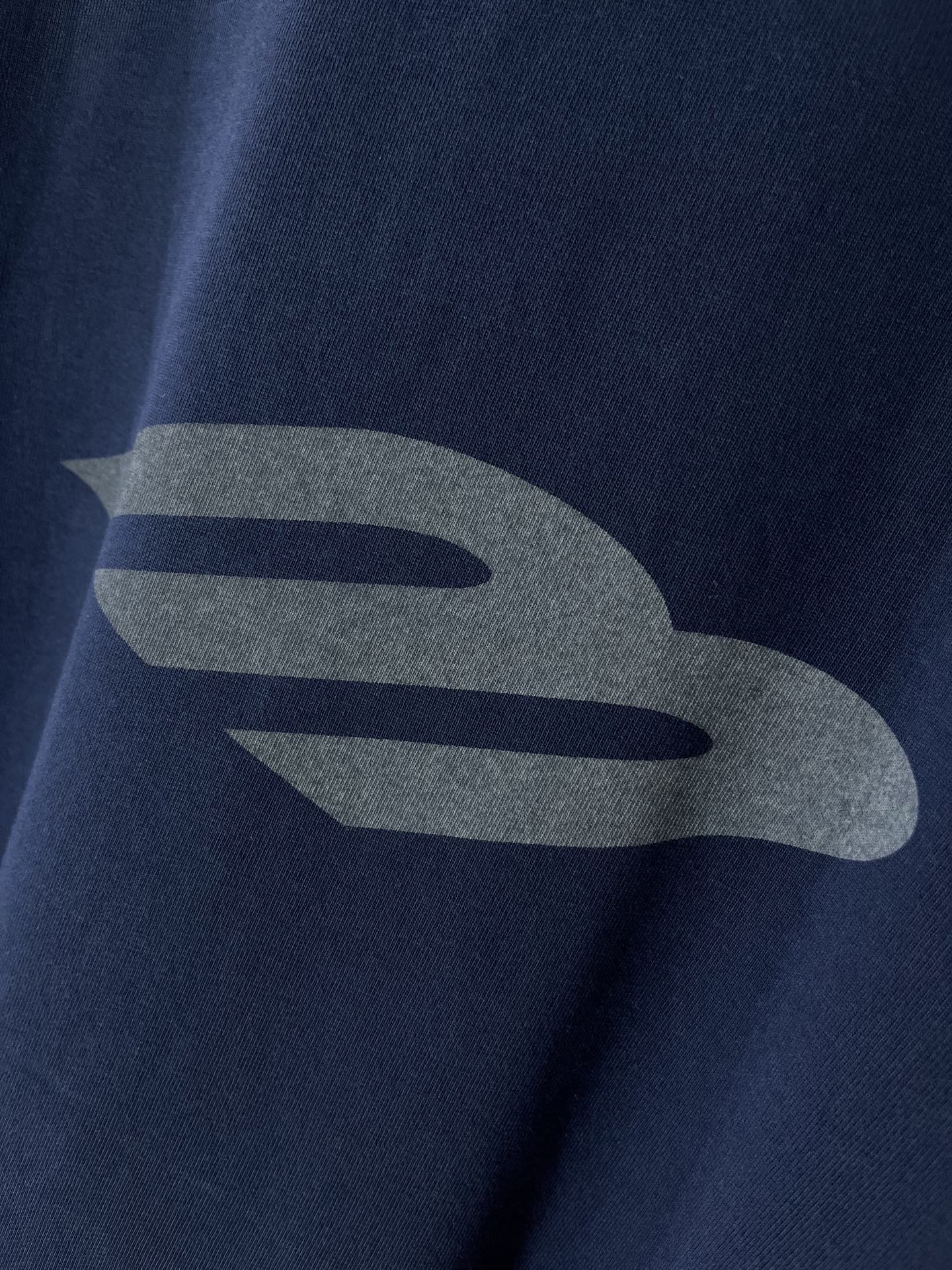 Navy T-shirt with large grey graphic detail on the chest