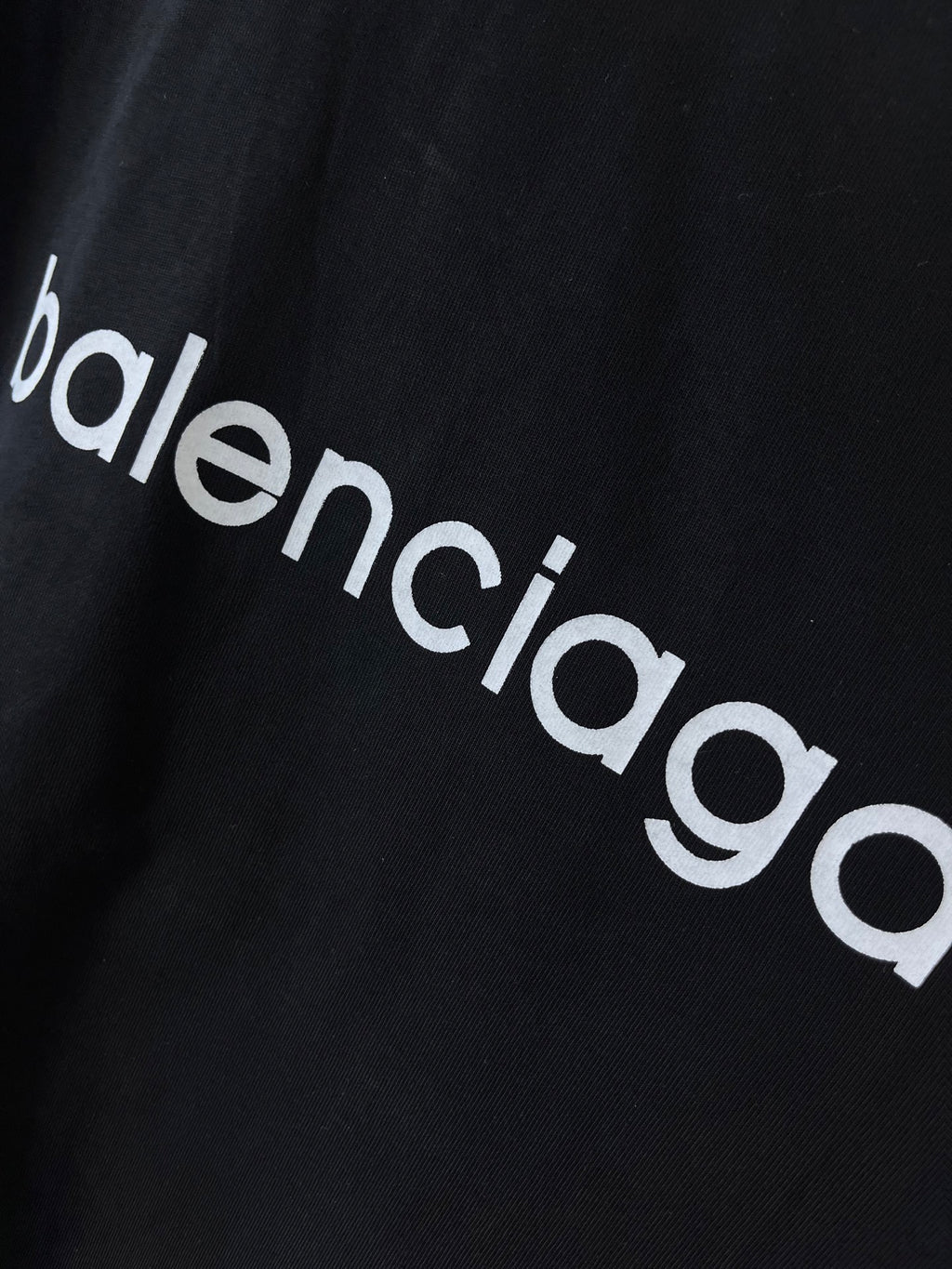 Dark navy T-shirt fabric close-up with 'balenciaga' wordmark